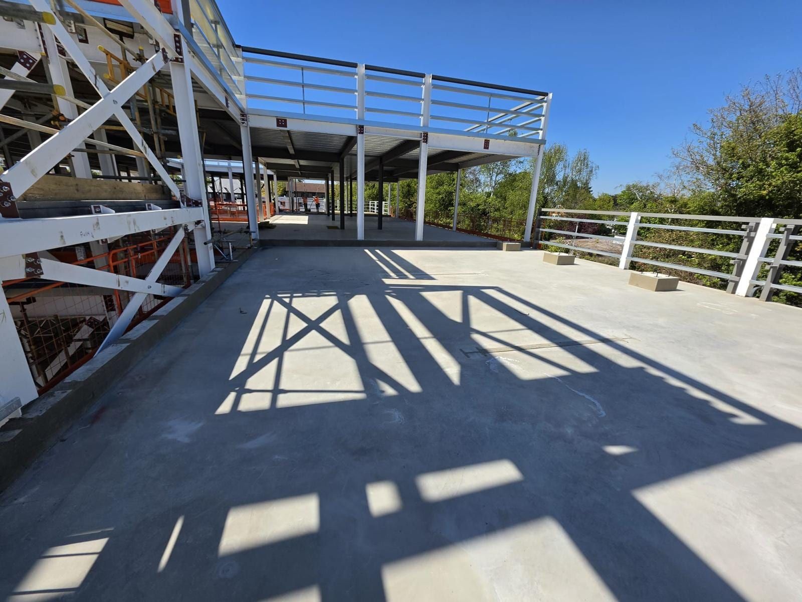 Shadows of a steel frame falling across a finished power floated concrete slab